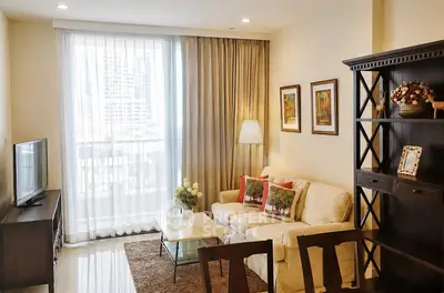 Charming living room with cozy sofa, elegant decor, and city view through large window.