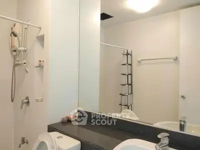 Modern bathroom with sleek fixtures and large mirror in a contemporary home.