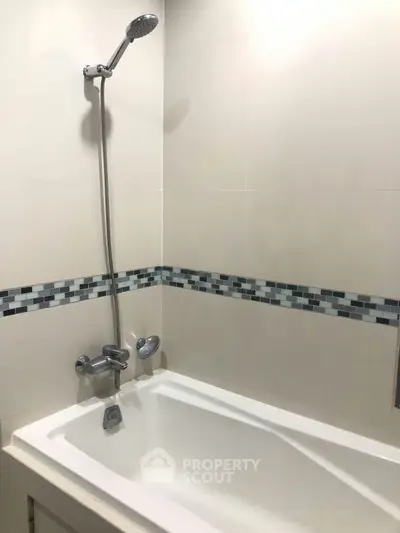 Modern bathroom with sleek bathtub and stylish tile accents.