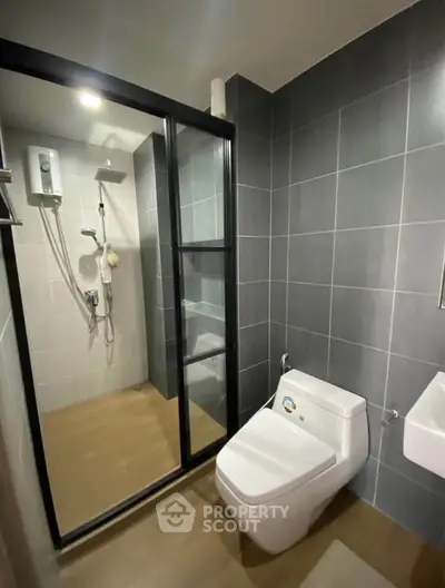 Modern bathroom with sleek shower and contemporary fixtures in stylish apartment.