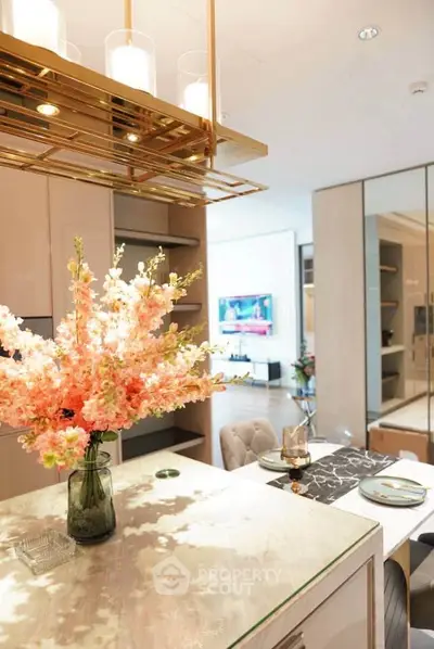 Luxurious modern kitchen with elegant decor and open layout, featuring stylish lighting and floral centerpiece.
