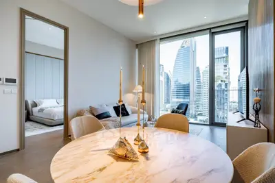 Luxurious modern apartment with stunning city view, featuring elegant dining area and cozy bedroom.