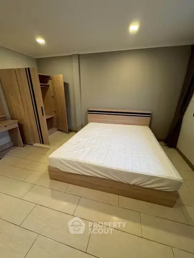 Spacious bedroom with modern wooden furniture and cozy lighting