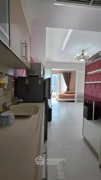 Modern apartment interior with open kitchen and living area, featuring sleek design and ample natural light.