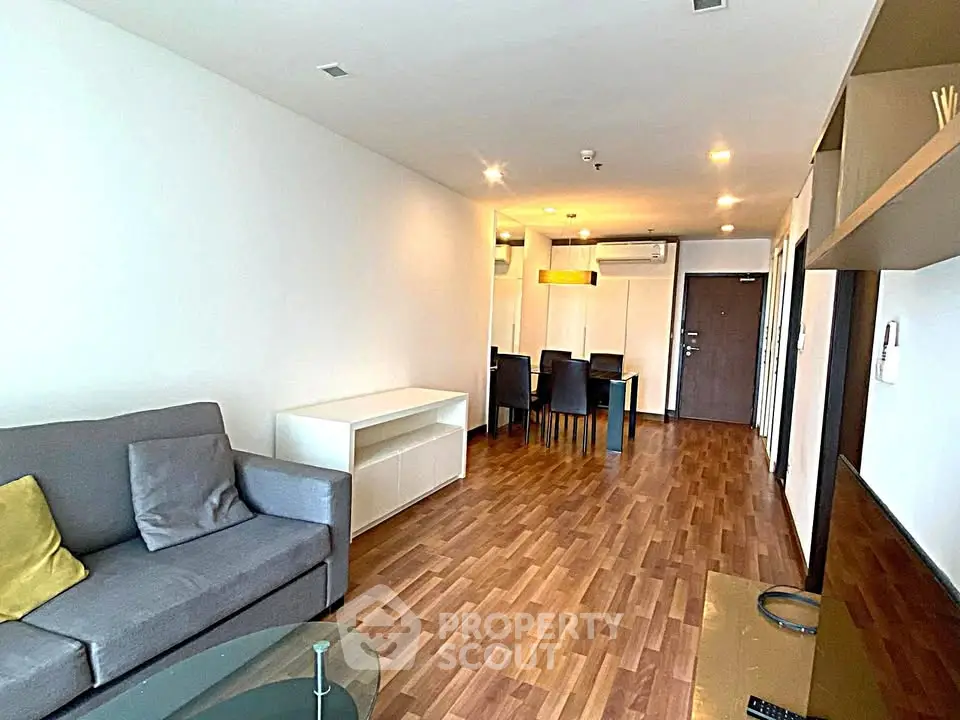 Spacious modern living room with wooden flooring and stylish furniture in a contemporary apartment.
