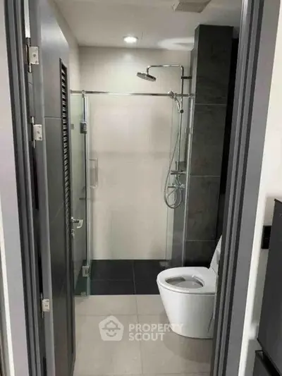 Modern bathroom with sleek shower and toilet in contemporary apartment.