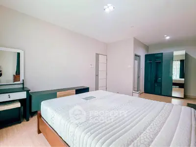 Spacious bedroom with modern furniture and ample natural light