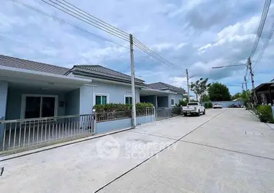 Charming suburban residential street with modern single-story homes and spacious driveways.