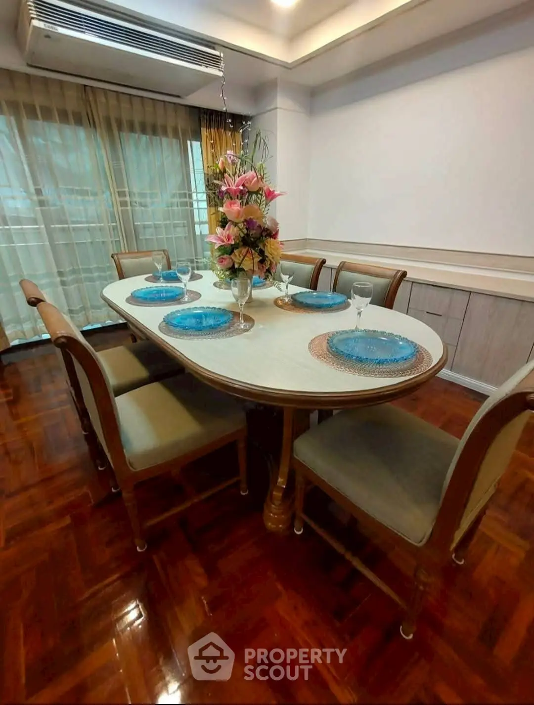 Elegant dining room with wooden flooring and stylish table setup.