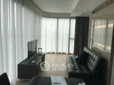 Spacious modern living room with floor-to-ceiling windows and sleek furnishings.