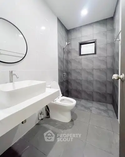 Modern bathroom with sleek gray tiles and minimalist fixtures.