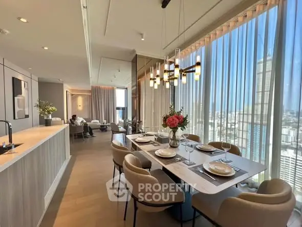 Luxurious open-plan living and dining area with stunning city views and elegant decor.