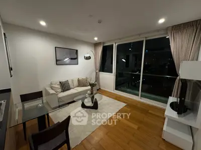 Modern living room with stylish decor and large windows offering city views.