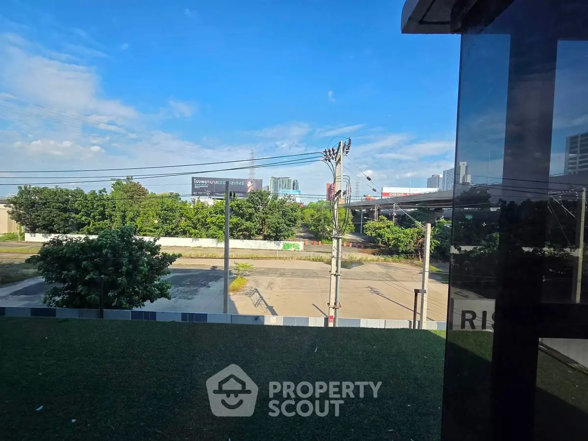 Stunning urban view from a modern building with lush greenery and city skyline.