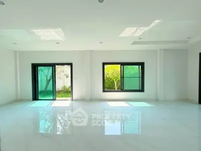 Spacious modern living room with large windows and garden view