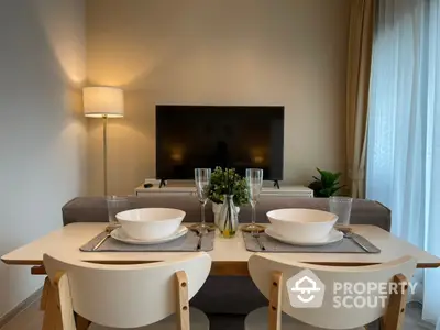 Elegant dining area seamlessly connected to a cozy living space, featuring modern furniture and tasteful decor, ideal for intimate gatherings.