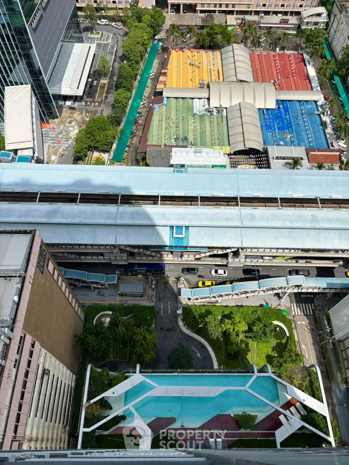 Stunning aerial view of urban landscape with modern buildings and pool, showcasing vibrant city life and architecture.