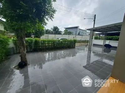 Spacious modern garden with sleek tiled flooring and lush greenery