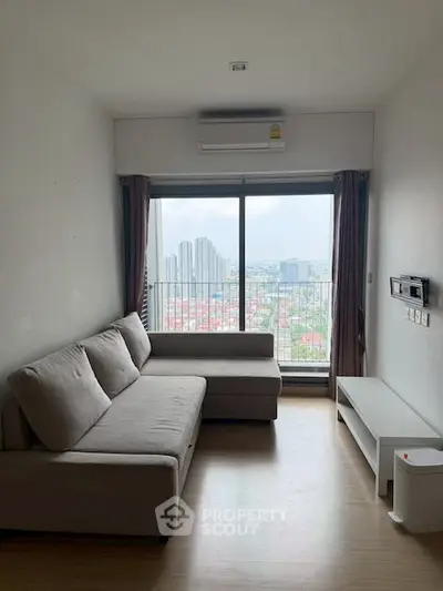 Modern living room with city view, featuring a cozy sofa and large window.