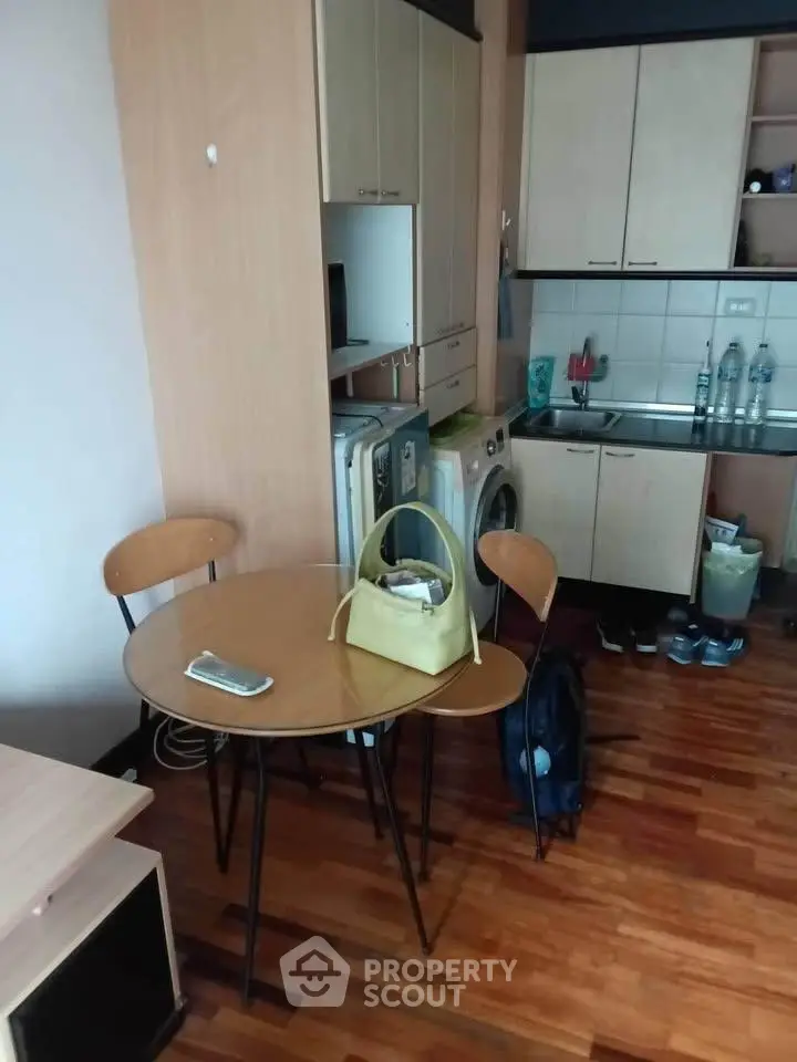 Cozy kitchen with compact dining area and washing machine in modern apartment.
