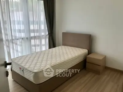 Cozy bedroom with natural light and modern furnishings in a stylish apartment.