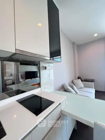 Modern kitchen with sleek design and open layout adjacent to cozy living area.