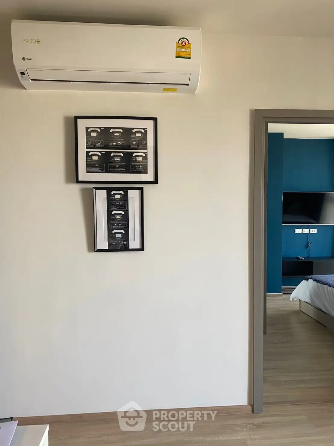 Modern bedroom with air conditioning and framed art, showcasing sleek design and comfort.