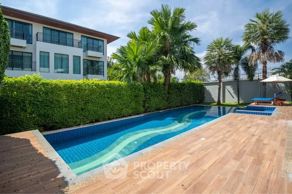 Luxurious private pool with lush greenery and modern building backdrop