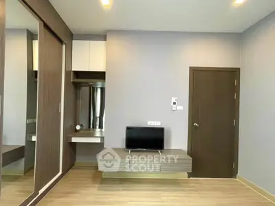 Modern living room with sleek wooden flooring and built-in TV unit