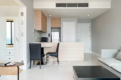 Modern open-plan living room with sleek kitchen and stylish furniture in a contemporary apartment.