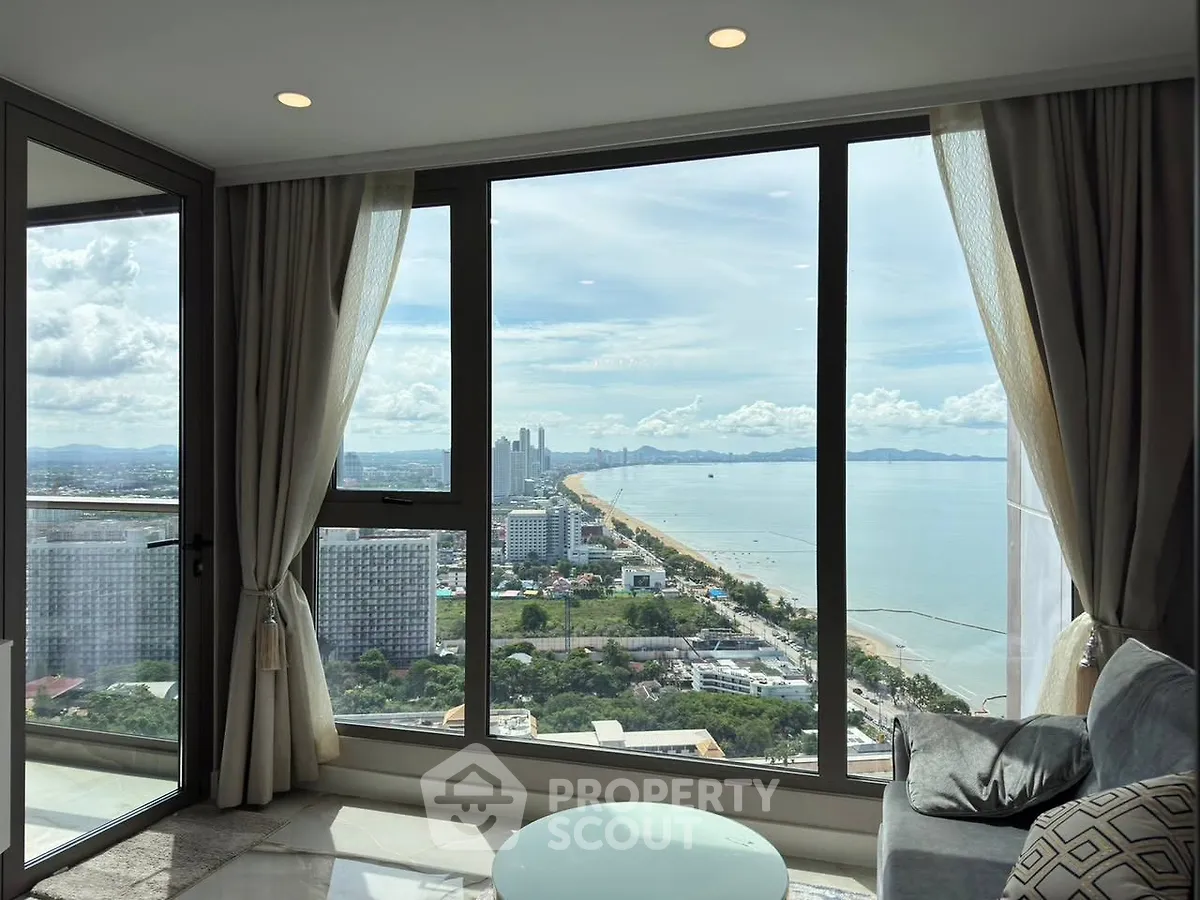 Stunning high-rise living room with panoramic ocean view and modern decor.