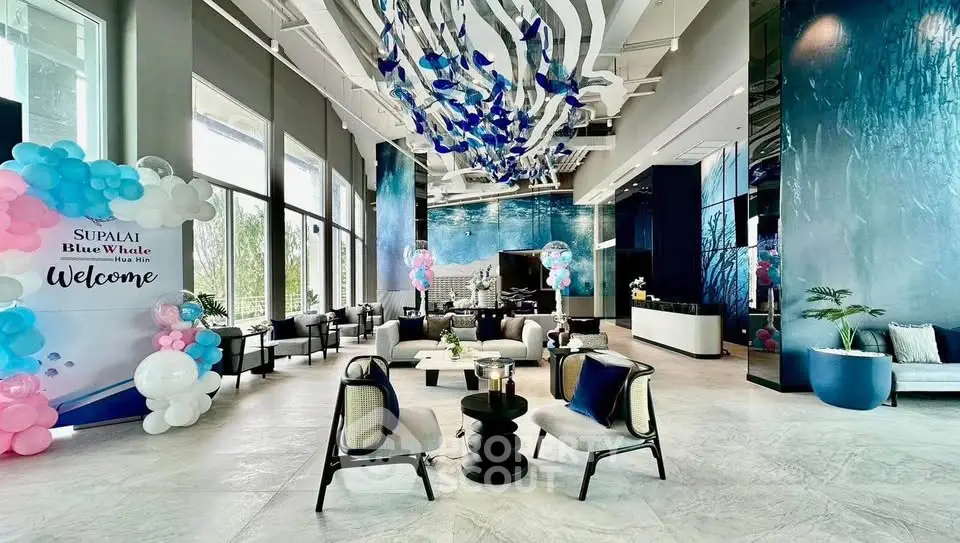 Luxurious modern lobby with elegant seating and artistic ceiling decor in a high-end building.
