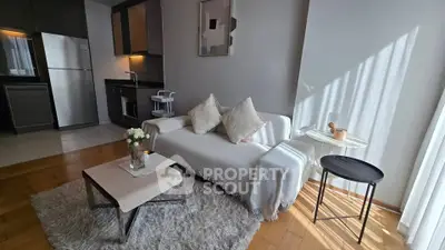 Modern living room with cozy sofa, stylish decor, and open kitchen layout in a bright apartment.