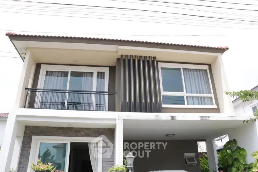 Modern two-story house with large windows and a stylish facade.
