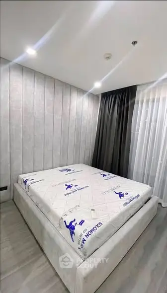 Modern bedroom with stylish decor and cozy ambiance, featuring a comfortable bed and elegant lighting.