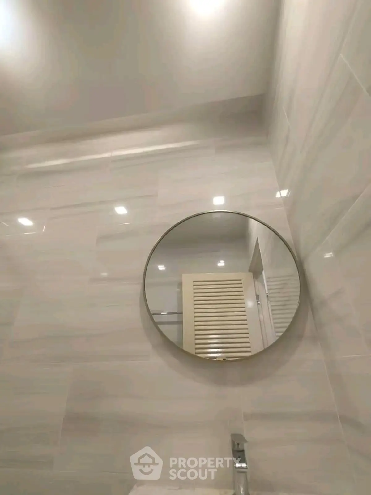 Modern bathroom with round mirror and sleek tile design
