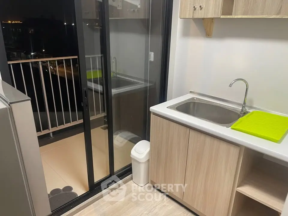 Modern kitchen with balcony access and sleek cabinetry, perfect for urban living.