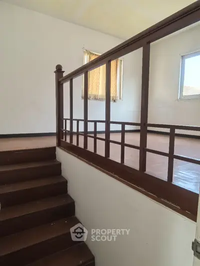 Spacious interior with wooden staircase and natural light, ideal for modern living.