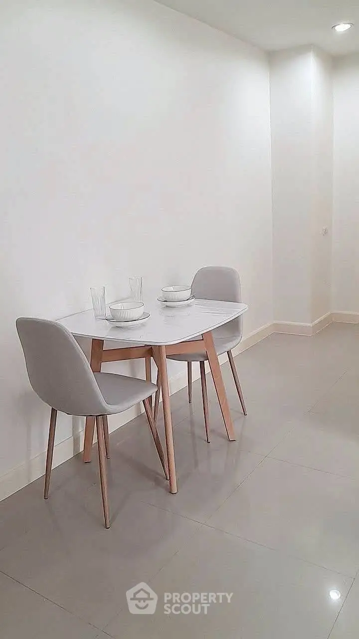 Minimalist dining area with modern table and chairs in a bright, spacious room.