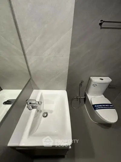 Modern bathroom with sleek sink and toilet in a contemporary real estate property.