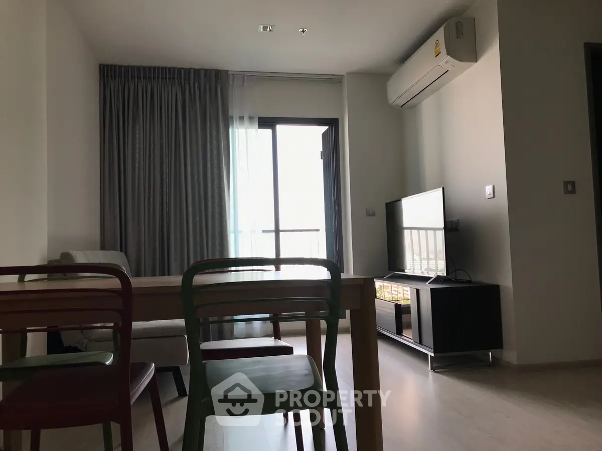 Modern living room with balcony, air conditioning, and stylish furniture in a contemporary apartment.