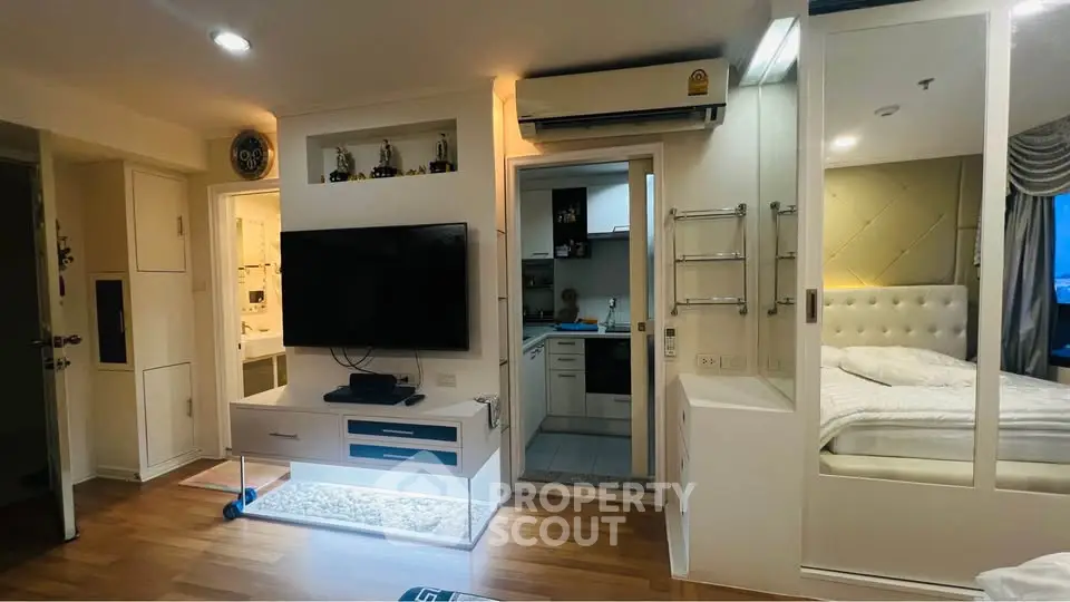 Modern apartment interior with open living area, kitchen, and bedroom, featuring sleek design and cozy ambiance.