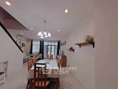 Spacious dining area with elegant lighting and modern decor in a stylish home.