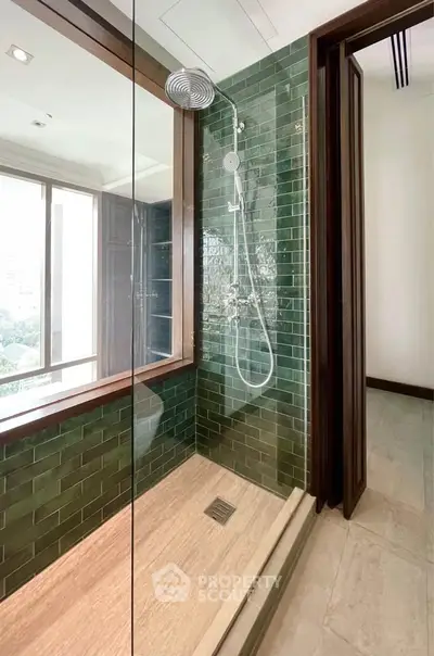 Luxurious bathroom with green tiled shower and large window view.