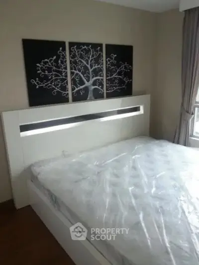 Modern bedroom with stylish headboard and elegant wall art