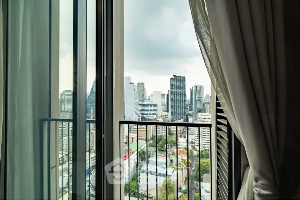 Stunning city view from a modern apartment balcony with elegant curtains.