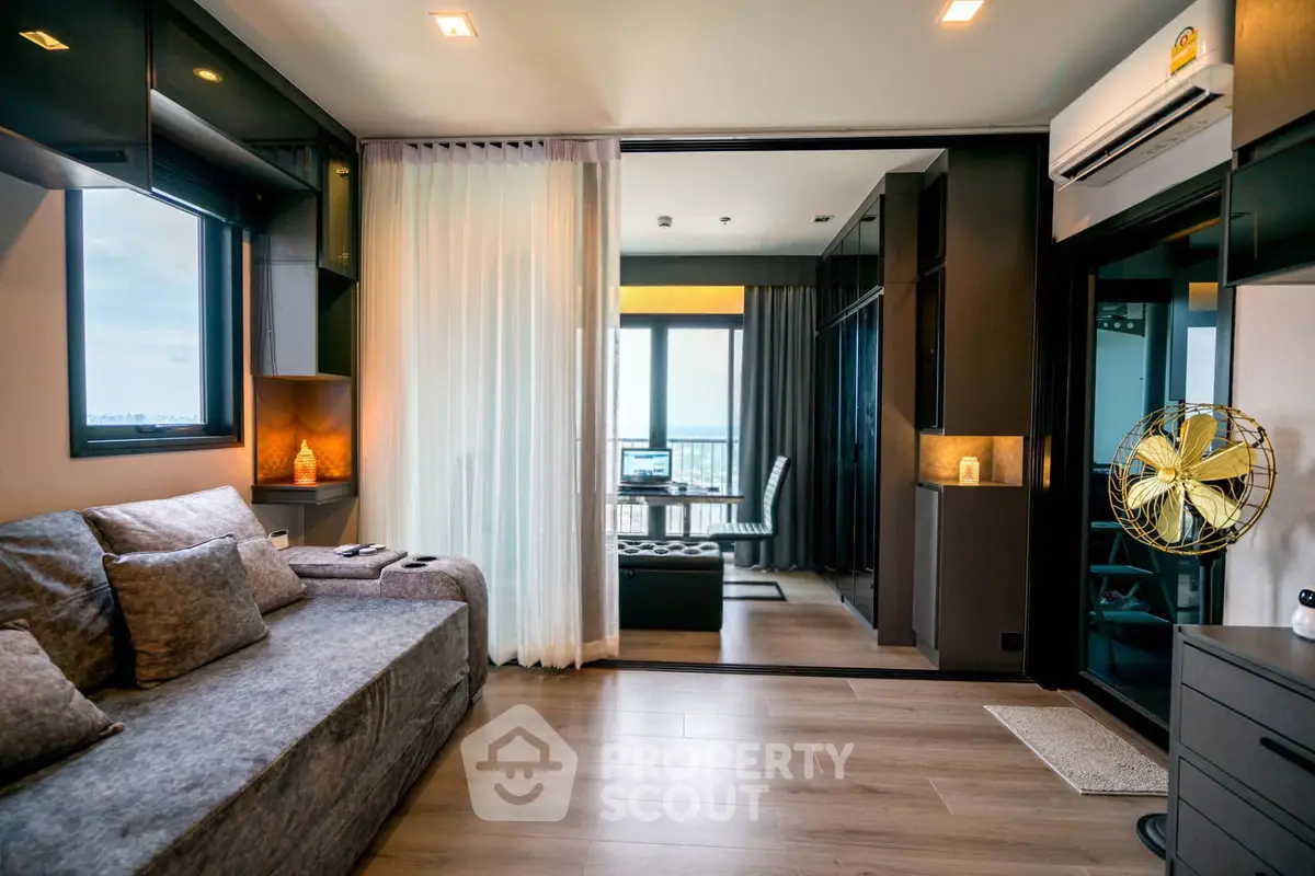 Modern living room with stylish decor and large windows offering stunning city views.
