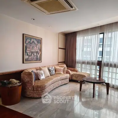 Spacious living room with elegant sofa and large windows in modern apartment.