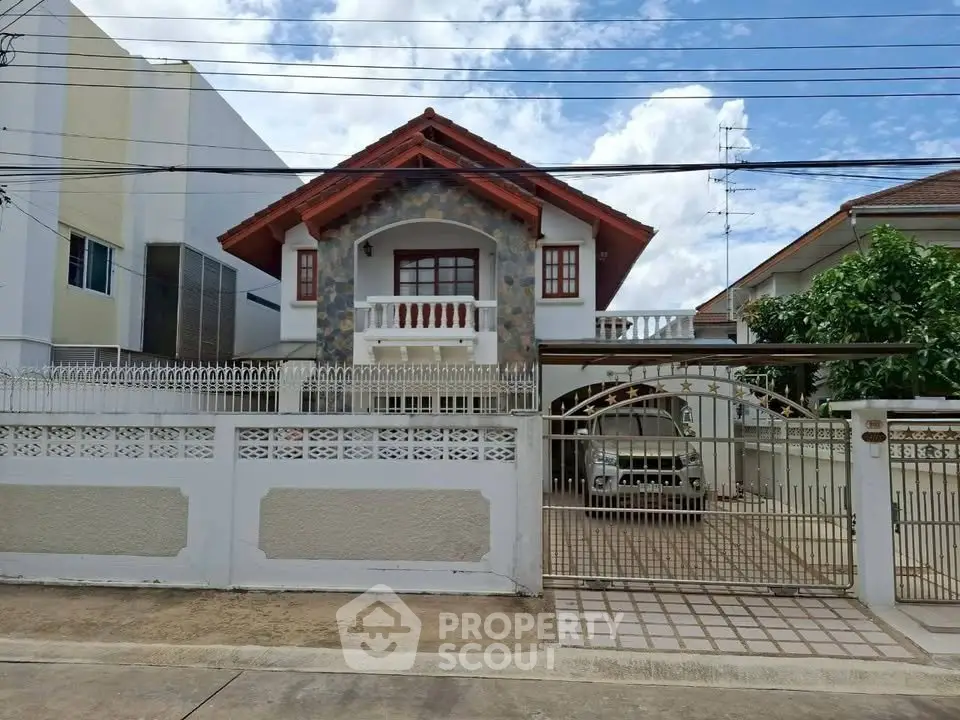 Charming two-story house with unique stone facade and gated driveway in a serene neighborhood.