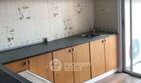 Charming kitchen with wooden cabinets and sliding glass door access.